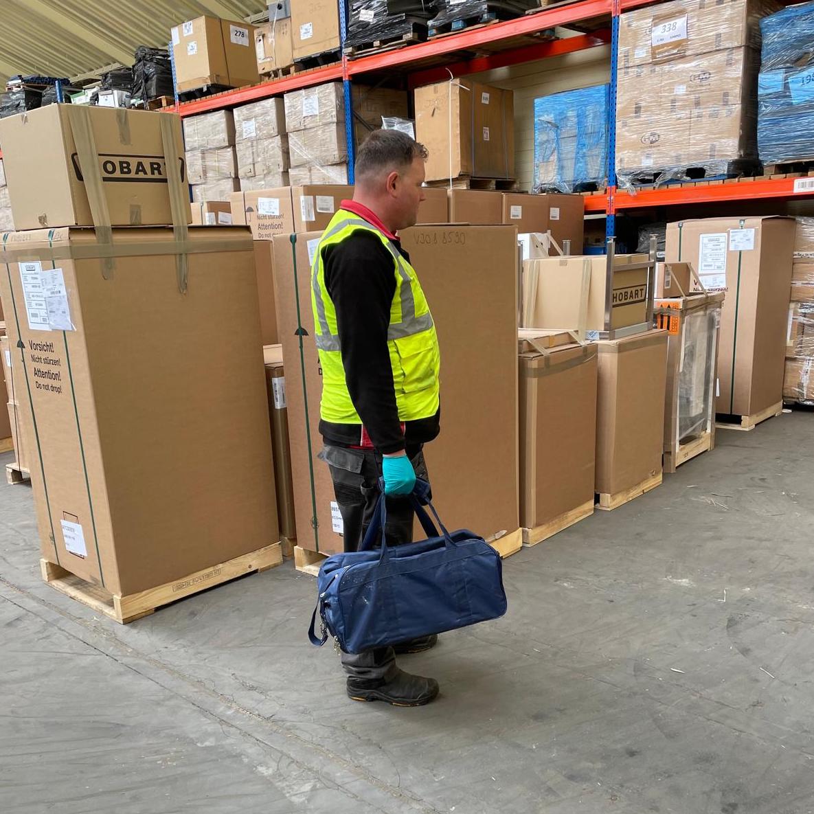 Don Valley pest controller in a branded high-vis vest attending a commercial pest control job at a warehouse.