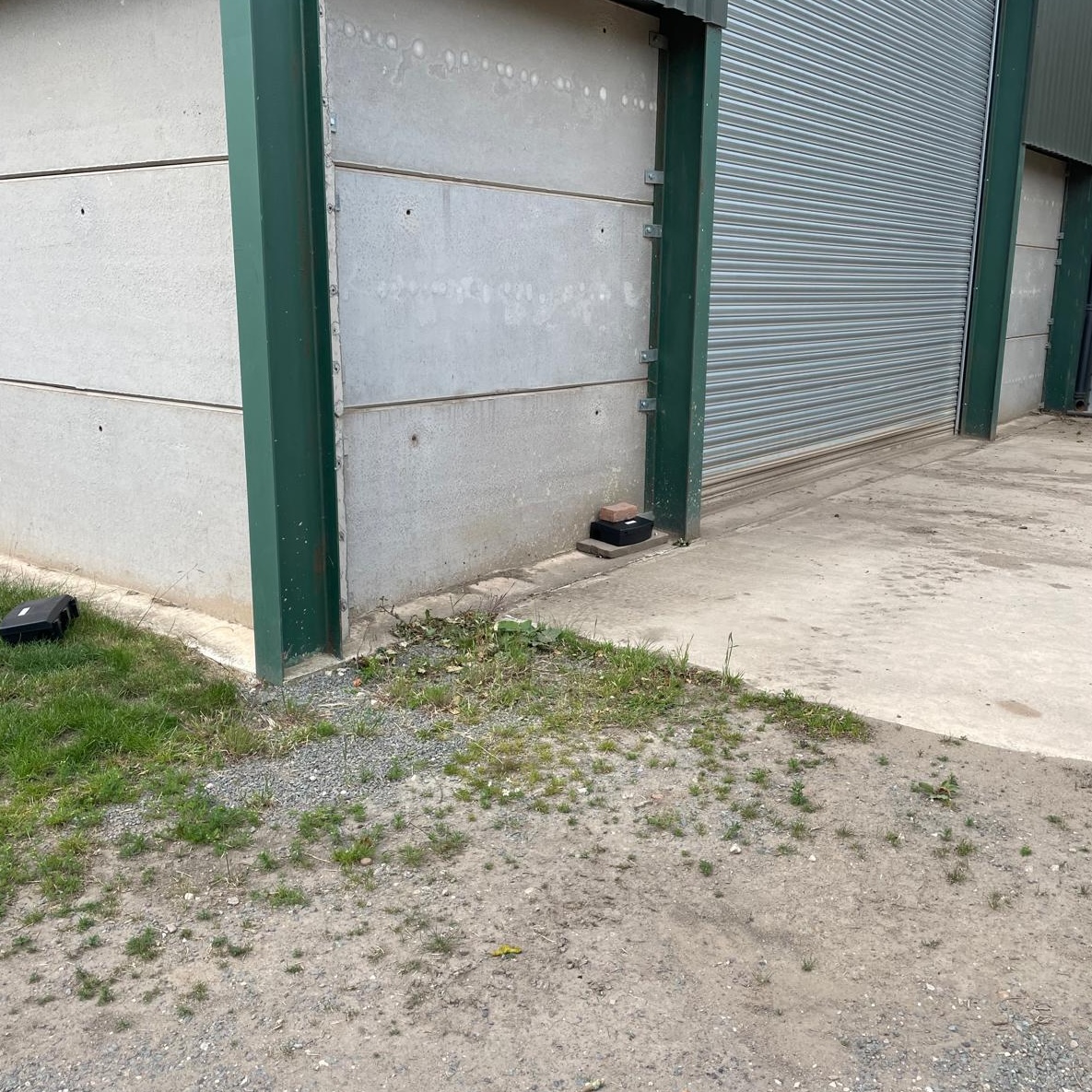 Pest control at a farm, with bait boxes surrounding a large barn.